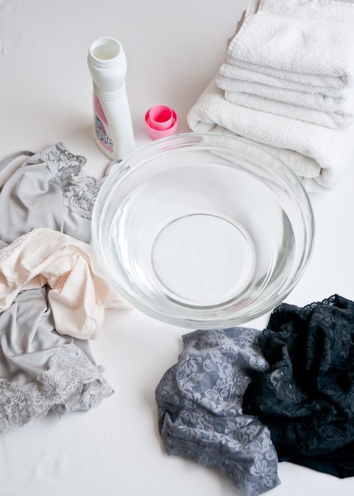 how to wash lingerie guide showing a bowl, towels, delicate detergent, and underthings