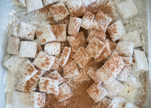 Dusting homemade marshmallows with cocoa powder