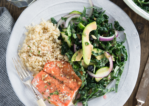 healthy dinner of salmon with kale salad and quinoa