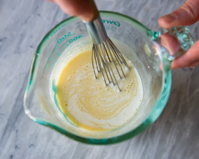 making creme brulee - adding hot cream to egg yolks and sugar